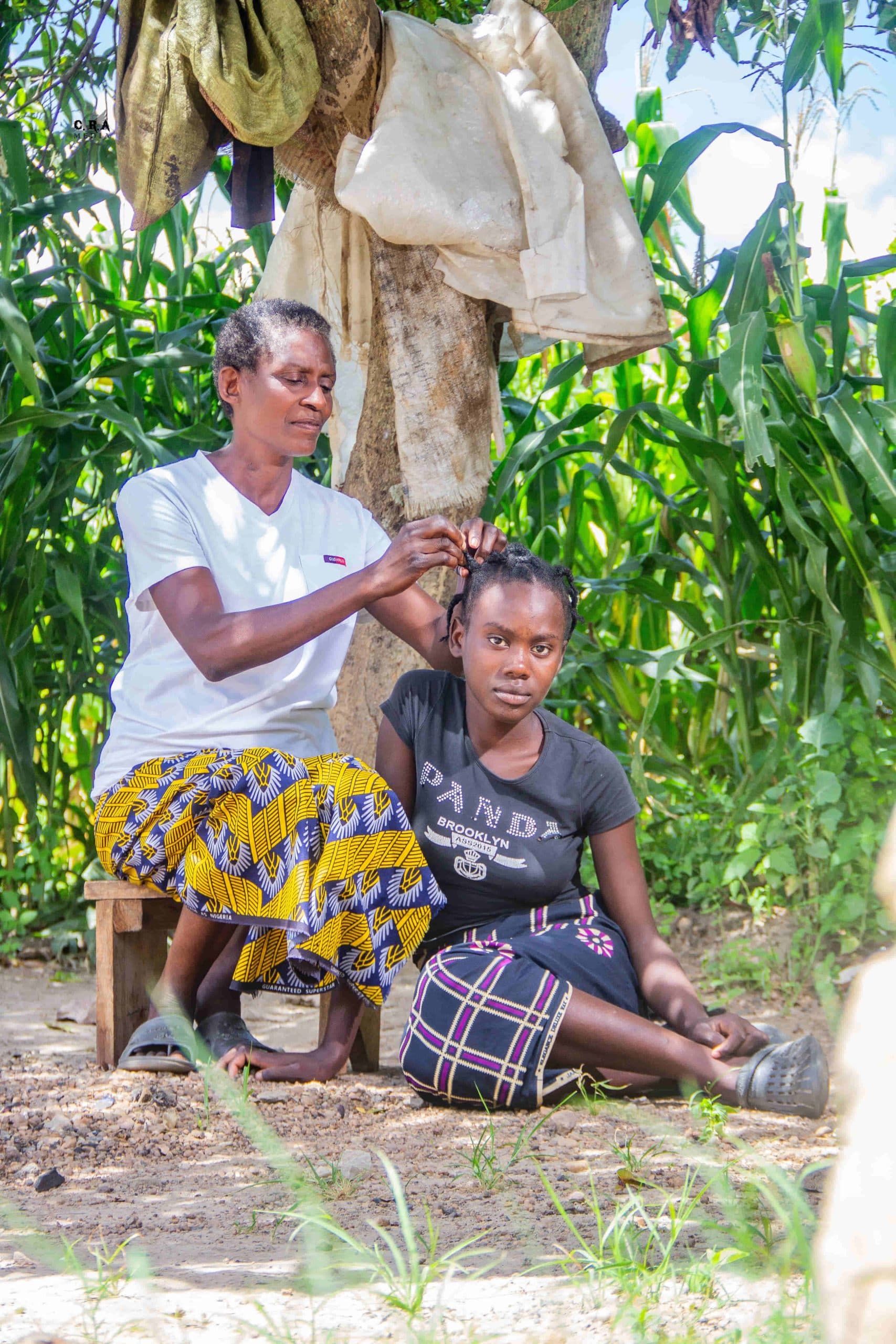 A mother braiding her daughter's hair at home