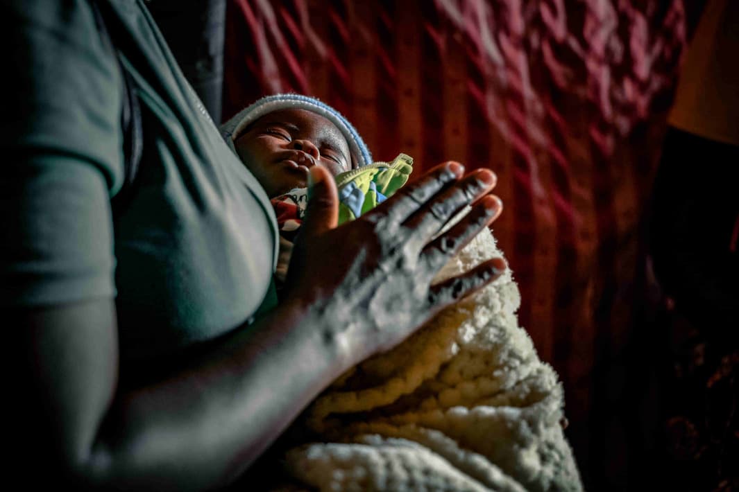 A mother holding her baby, supported by a PCZ case worker