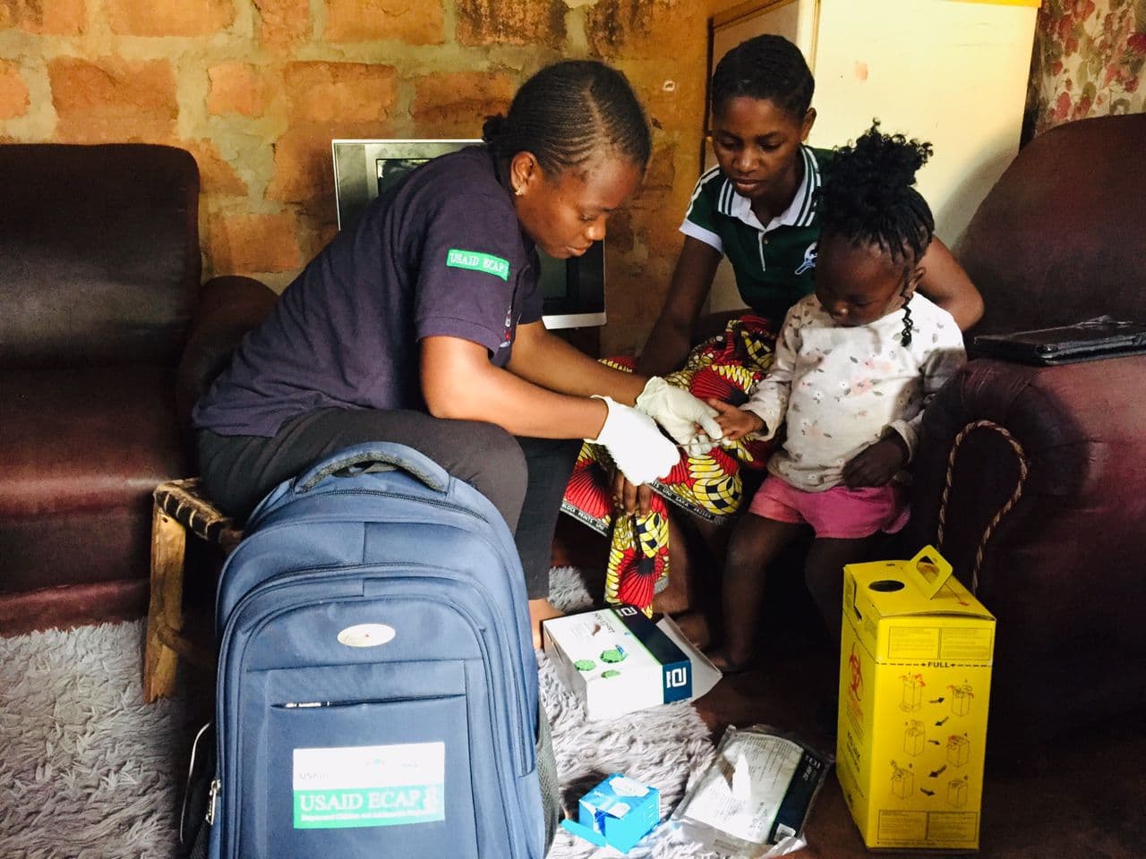 A PCZ case worker on a home visit with a family